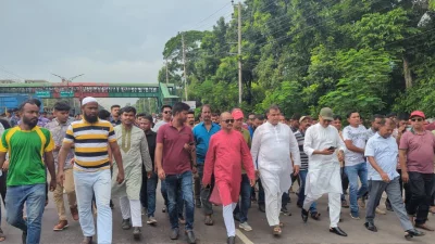 The image shows Member of Parliament for the Dhaka-19 constituency Saiful Islam, along with activists and vehicles, passing the highway on foot after getting out from his car being obstructed by protesting students on the Dhaka-Aricha highway in Savar on Wednesday, July 3, 2024. Photo: Dhaka Tribune