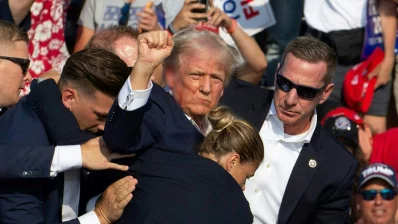 Republican candidate Donald Trump is seen with blood on his face surrounded by secret service agents as he is taken off the stage at a campaign event at Butler Farm Show Inc in Butler, Pennsylvania, July 13, 2024. Photo: AFP