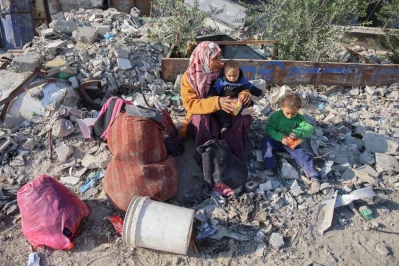 A woman rests with her children as displaced Palestinians flee Beit Lahia in the northern Gaza Strip, through the main Salah al-Din road on the outskirts of Gaza City, on November 5, 2024. Photo: AFP