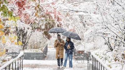 Pedestrians walk in Gwanghwamun near Gyeongbokgung Palace amid heavy snowfall in central Seoul on November 27, 2024. Photo: AFP