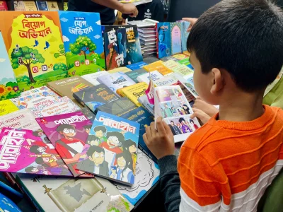 A little booklover reading and choosing his books from the fair. Photo: Yousha Tashfi/Dhaka Tribune
