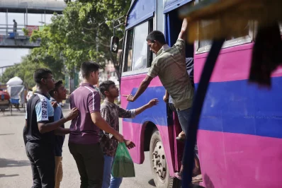 Passengers board a pink bus on the Gazipur-Gulistan-Shimultali route in Dhaka, where the much-publicised ticket counter-based service has lost its structure and now operates like a regular local bus, June 25, 2025. Photo: Mehedi Hasan/Dhaka Tribune