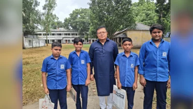 The author standing with students in blue uniforms outside Matta High School in Manikganj. Photo: Dhaka Tribune/Collected