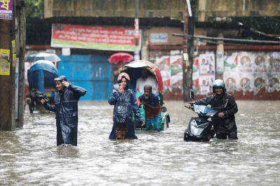 People wade through waterlogged roads in front of the Dhaka Education Board at Bakshi Bazar after heavy monsoon rain inundated the area, disrupting traffic and daily movement in the capital on Sunday. Photo: Ahadul Karim Khan/Dhaka Tribune