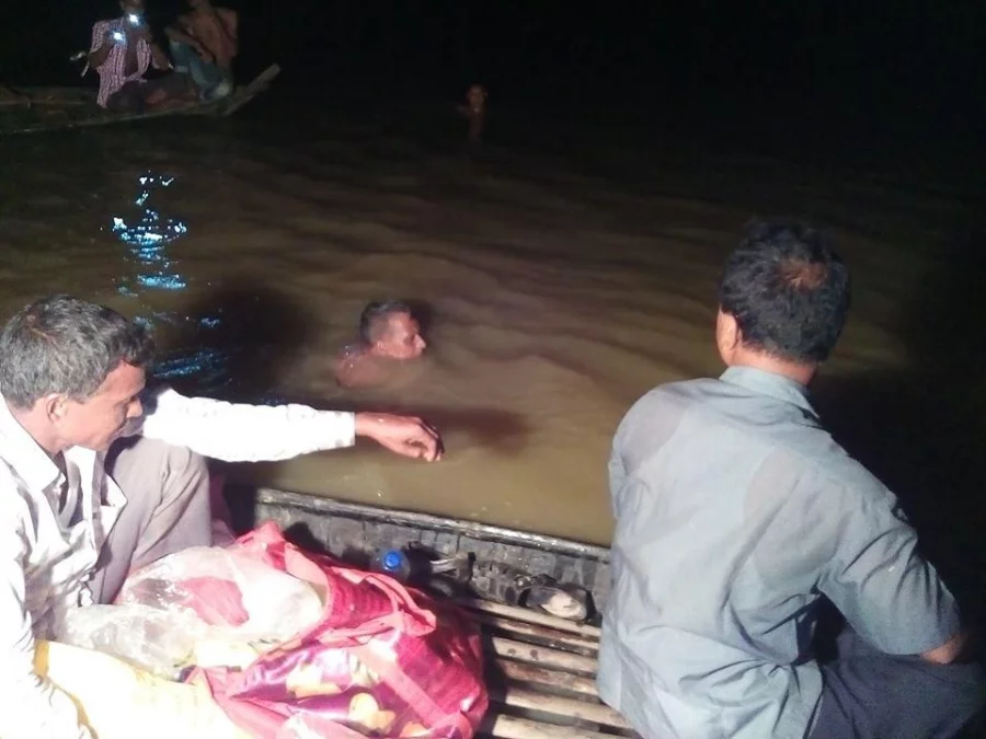 A boat carrying representatives of the local administration, the media and sports personalities follow Khitindra as he completes his 146km swim down the Kangha River Dhaka Tribune