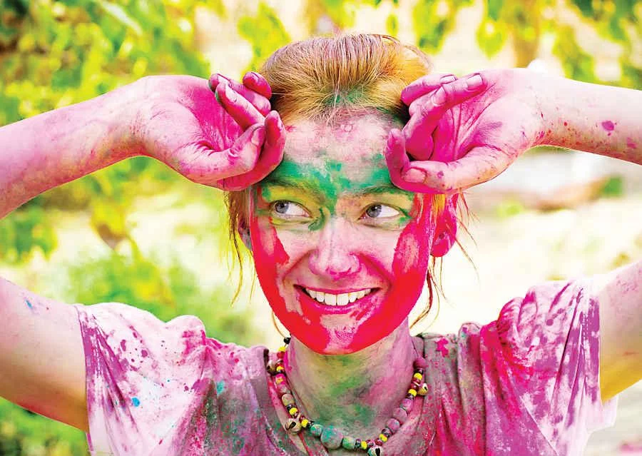 DELHI INDIA - MARCH 20: Tourist with students of Jawaharlal Nehru University celebrate festival Holi on March 20 2011 in Delhi India. Holi is a spring festival celebrated as a festival of colors.