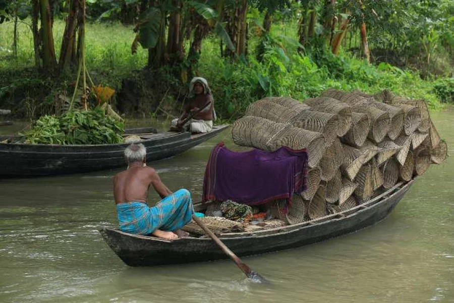 A man taking goods to a floating market. Photo: Syed Zakir Hossain/Dhaka Tribune