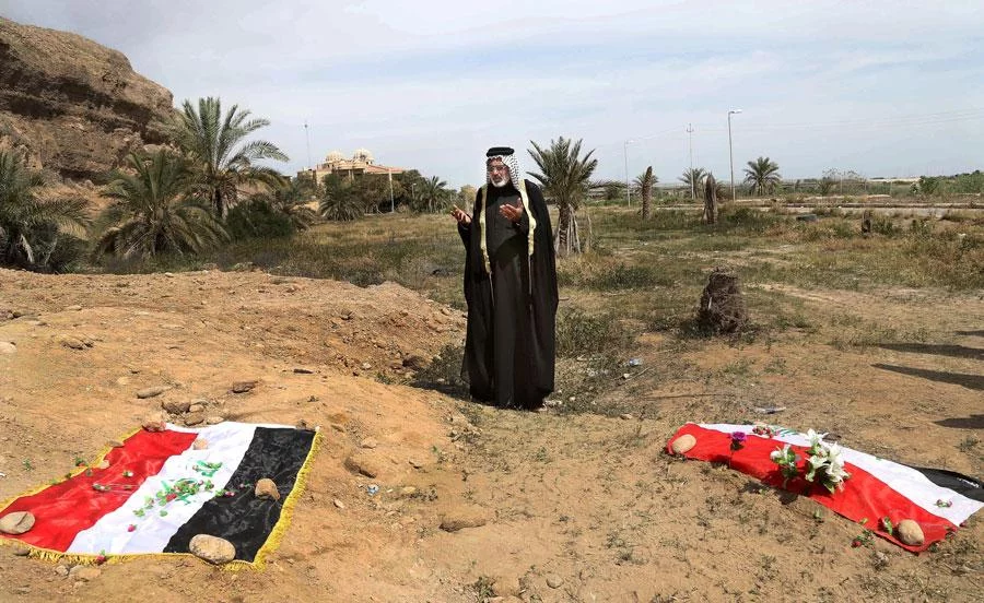 In this April 3, 2015, file photo, an Iraqi man prays for his slain relative at the site of a mass grave believed to contain the bodies of Iraqi soldiers killed by Islamic State group militants when they overran Camp Speicher military base in Tikrit, Iraq, in June 2014 AP