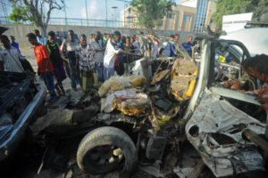 EDITORS NOTE: Graphic content / Residents look inside the wreckage of a car bomb outside Banadir beach restaurant in the capital Mogadishu on August 26, 2016 a day after an attack by alleged Al-Qaeda-linked Shebab rebels killed nine people including the assailants, according to Mogadishu city spokesman. Al-Qaeda-linked Shebab rebels attacked a beachfront restaurant in the Somali capital Mogadishu on August 25, setting off a car bomb before exchanging fire with security forces, an AFP correspondent said. The Al-Qaeda-linked Shabaab group claimed responsibility for the attack through the website of their Andalus radio station. / AFP PHOTO / Mohamed ABDIWAHAB