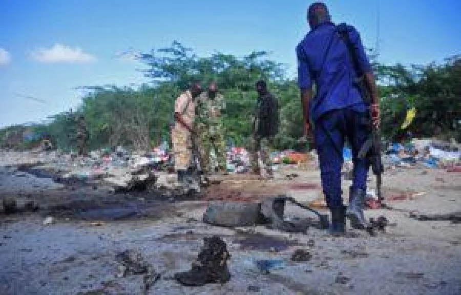Members of the Somalian military forces stand at the site of a suicide car bomb attack, which killed a top Somalia general along with four of his security guards, near Gashandhiga compound, south of Mogadsihu, on September 18, 2016. General Mohamed Roble Jimale Gobale, known for fighting the jihadist Shabaab group, was killed on September 18 when a suicide bomber rammed an explosives-packed car into his vehicle, officials and witnesses said. The attack was claimed by the Al-Qaeda linked Shabaab. / AFP PHOTO / Mohamed ABDIWAHAB