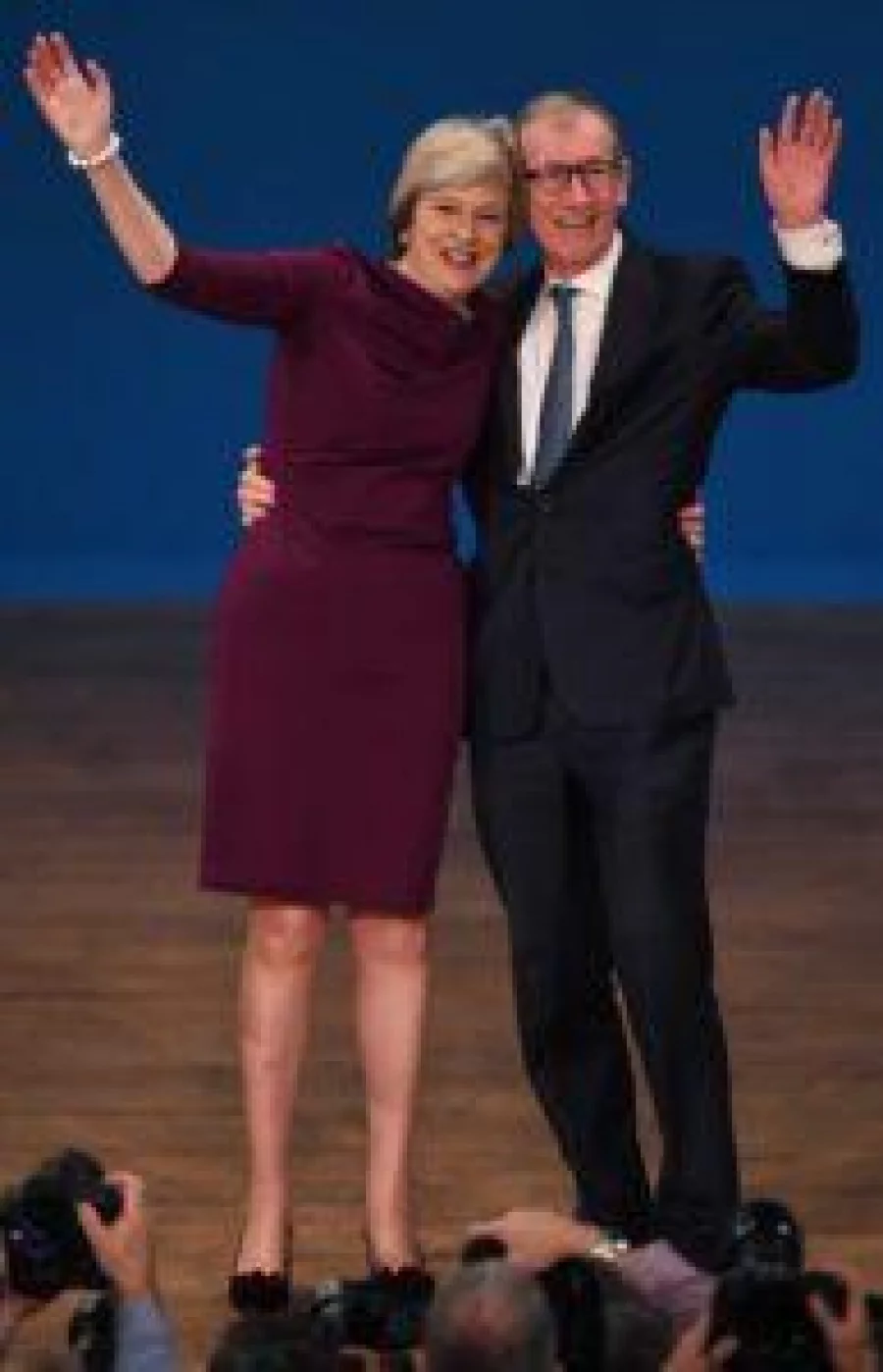 British Prime Minister Theresa May (L) stands with her husband Philip John May, as they wave to delegates following her keynote address on the final day of the annual Conservative Party conference at the International Convention Centre in Birmingham, central England, on October 5, 2016.  Brexit prompted the resignation of the UK's prime minister and the reshaping of the country's government, but the ruling Conservative Party has already rebounded and is showing a united front. The jubilant mood at the annual Conservatives conference is being led by its hardline eurosceptics -- for years the awkward squad within the party.  / AFP PHOTO / PAUL ELLIS