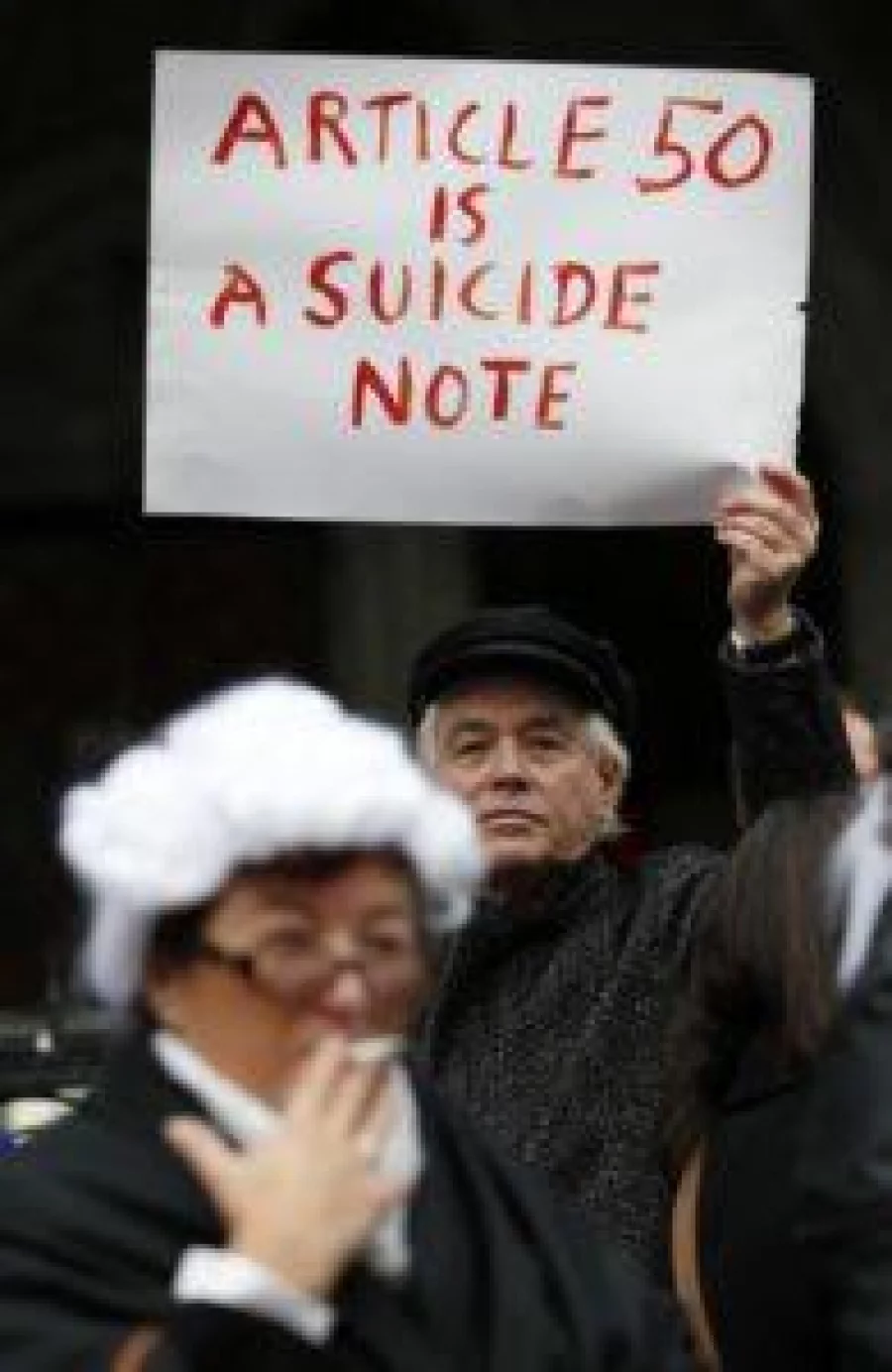 A pro-Brexit supporter (L) from Invoke Article 50 Now!, dressed as a judge, stands in front of a Pro-European Union (EU) supporter outside the entrance to The Royal Courts of Justice, Britain's High Court, in London on October 13, 2016, during a protest against the UK's decision to leave the EU. The battle over Britain's exit from the European Union (Brexit) reached the High Court on Thursday in a legal challenge to Prime Minister Theresa May's right to start negotiations for Britain to leave the EU without a vote in parliament. The move could delay Brexit if successful and set up an unprecedented constitutional face-off between the courts and the government. / AFP PHOTO / ADRIAN DENNIS