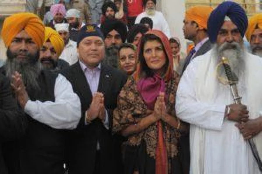 Governor of the US State of South Carolina Nikki Haley (2R), her husband Michael Haley (2L), Sikh head Priest Jaswinder Singh (R) and officials pose at the Golden Temple in Amritsar on November 15, 2014. Haley  visited  the city to pay her respects at the Golden Temple and Jallianwala Bagh. Haley is in India to take forward her initiative to sell South Carolina as a profitable investment destination. Nikki Haley, whose parents immigrated to the US in 1960s, has recently been elected the governor of the US state.  AFP PHOTO/NARINDER NANU / AFP PHOTO / NARINDER NANU