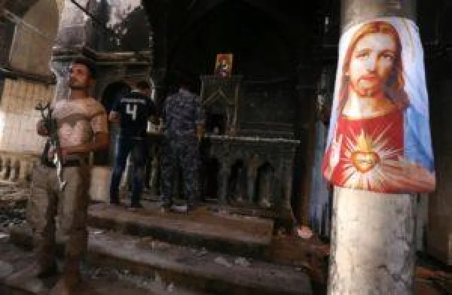 Iraqi Christian forces inspect the damage at the Church of the Immaculate Conception on October 30, 2016 in the town of Qaraqosh (also known as Hamdaniya), 30 kms east of Mosul, after Iraqi forces recaptured it from Islamic State (IS) group jihadists. Iraqi forces are fighting their way toward Mosul to retake it from IS in an operation that is now in its second week, and some Christian villages have already been retaken. / AFP PHOTO / SAFIN HAMED