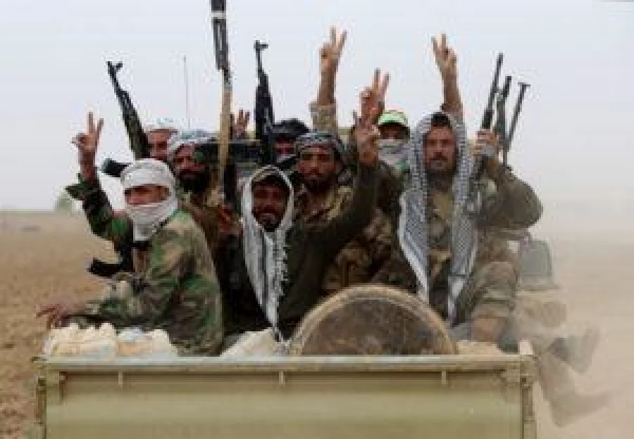 Shia fighters from the Hashed al-Shaabi flash the sign for victory as they enter the village of Abu Shuwayhah, south of Mosul, on November 1, 2016 AFP