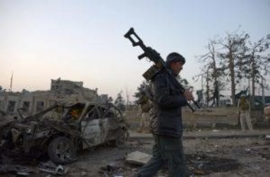 An Afghan security official walks at the site of an attack targeting the German consulate in Mazar-i-Sharif on November 11, 2016. / AFP PHOTO / FARSHAD USYAN
