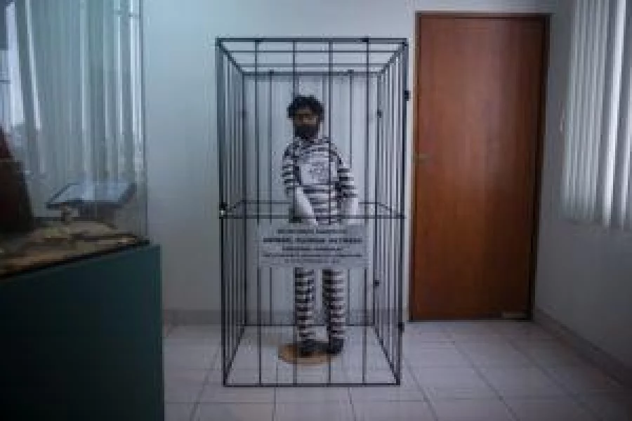 A dummy behind bars representing the leader of the terrorist group Sendero Luminoso (Shining Path), Abimael Guzman, is displayed in the small museum at the anti-terrorist direction Dircote that keeps some of Guzman's personal belongings and other stuff related to the group, in Lima, on October 27, 2016. A modest police museum keeps hundreds of personal belongings of the historical leader of the Maoist group Sendero Luminoso, Abimael Guzman, to show the threat posed by this fundamentalist guerrilla to Peru. / AFP PHOTO / Ernesto BENAVIDES