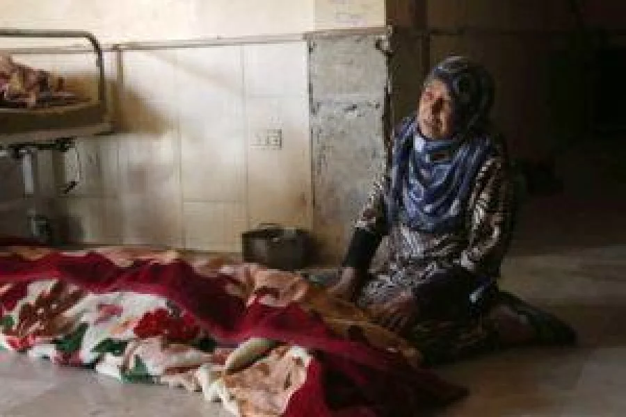 A Syrian woman mourns next to the body of her daughter at a hospital following reported air strikes on the town of al-Nashabiyah in the eastern Ghouta region, a rebel stronghold east of the capital Damascus, on November 20, 2016. / AFP PHOTO / AMER ALMOHIBANY