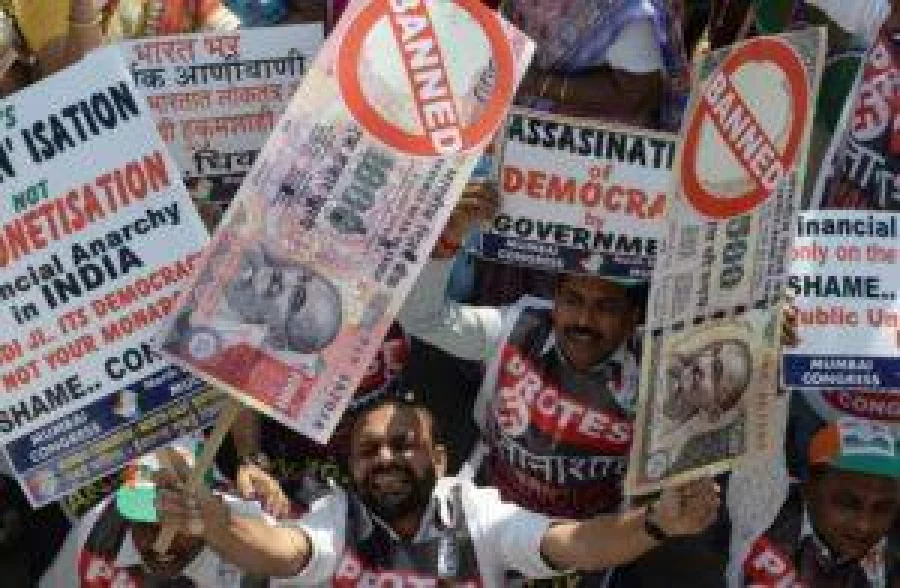 An Indian protestor holds placards of banned 500 and 1000 rupee notes during a protest against demonetisation, in Mumbai on November 28, 2016. Tens of thousands of people turned out November 28, for nationwide protests against India's controversial ban on high-value banknotes, which opposition party organisers say has caused a "financial emergency".  / AFP PHOTO / INDRANIL MUKHERJEE