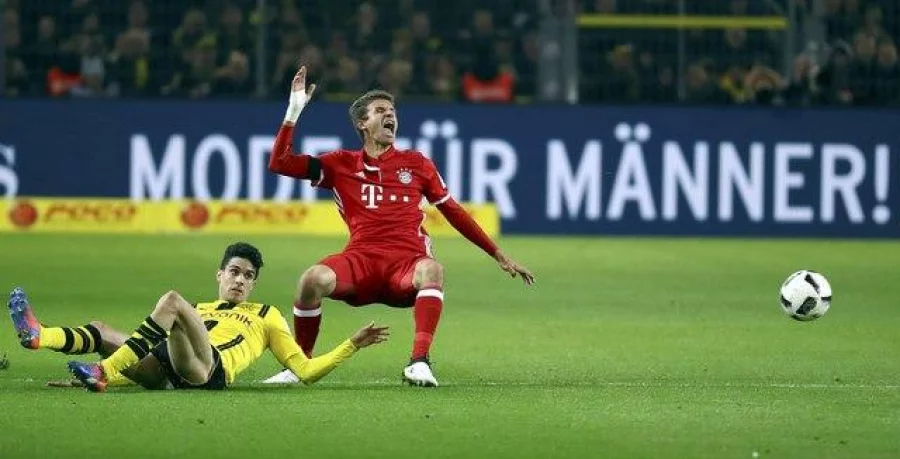 Football Soccer -  Borussia Dortmund v FC Bayern Munich - German Bundesliga - Signal Iduna Park, Dortmund, Germany - 19/11/16 - Dortmund's Marc Bartra Aregall and Munich's Thomas Mueller in action.   REUTERS/Kai Pfaffenbach  DFL RULES TO LIMIT THE ONLINE USAGE DURING MATCH TIME TO 15 PICTURES PER GAME. IMAGE SEQUENCES TO SIMULATE VIDEO IS NOT ALLOWED AT ANY TIME. FOR FURTHER QUERIES PLEASE CONTACT DFL DIRECTLY AT + 49 69 650050.