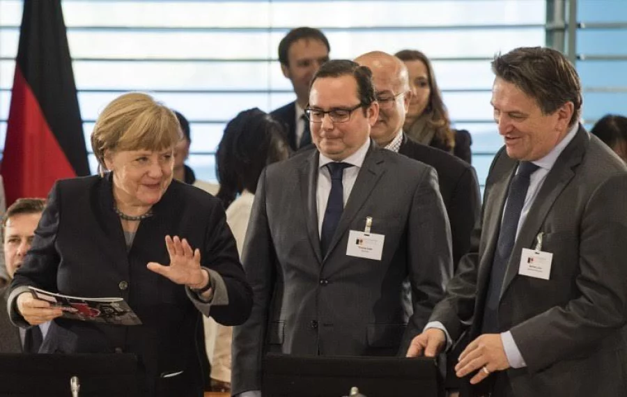 German Chancellor Angela Merkel (L) Essen's Mayor Thomas Kufen (C) and Chairman of the Minister's Conference on Integration Manfred Lucha (R) take part in an annual integration summit at the chancellery in Berlin on November 14, 2016. / AFP PHOTO / John MACDOUGALL