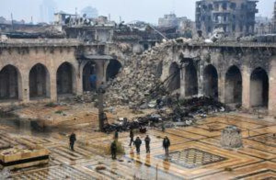 A general view shows Syrian pro-government forces walking in the ancient Umayyad mosque in the old city of Aleppo on December 13, 2016, after they captured the area. / AFP PHOTO / George OURFALIAN