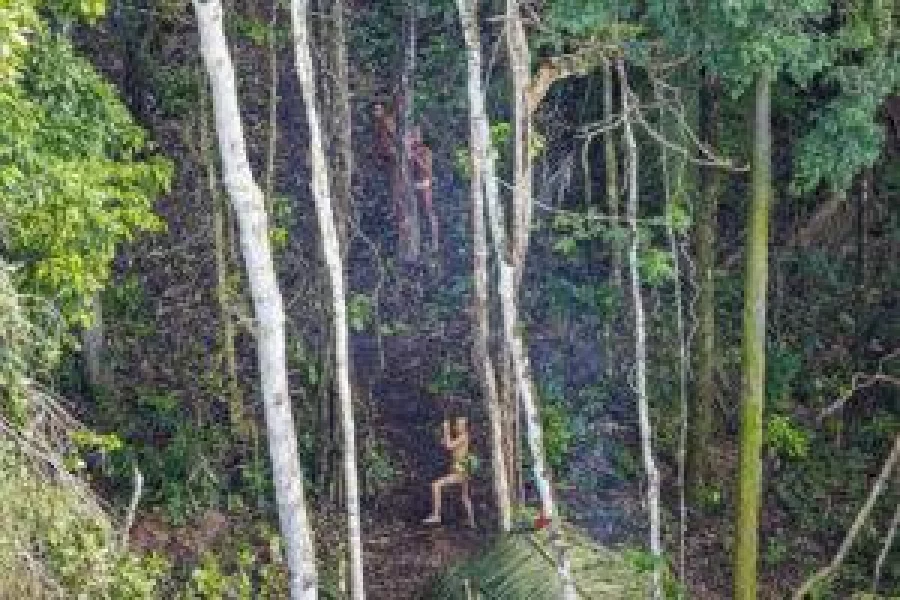 Tribesmen can be clearly seen from the air next to their settlement. THE GUARDIAN