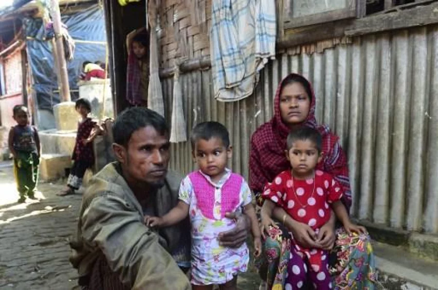 Deen Mohammad (L) and his wife Roshida (R), whose two elder sons were taken by the Myanmar military, pose for a photograph with their younger children after their escape from Myanmar, in a refugee camp in Teknaf in southern Cox's Bazar district on November 24, 2016. Dhaka has called on Myanmar to take "urgent measures" to protect its Rohingya minority after thousands crossed into Bangladesh in just a few days, some saying the military was burning villages and raping young girls. / AFP PHOTO / MUNIR UZ ZAMAN