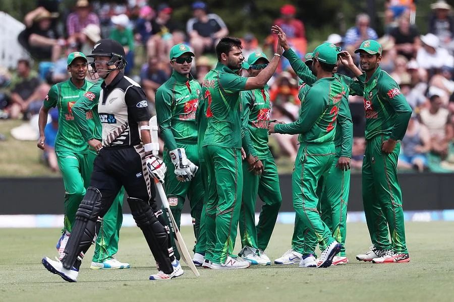 Mashrafe Mortaza of Bangladesh (C) celebrates his wicket with his team as Luke Ronchi of New Zealand leaves the field after being caught on the fist ball of the innings during the 20/20 Cricket International between New Zealand and Bangladesh at Bay Oval in Mount Maunganui on January 6, 2017. / AFP / Fiona Goodall / IMAGE RESTRICTED TO EDITORIAL USE - STRICTLY NO COMMERCIAL USE (Photo credit should read FIONA GOODALL/AFP/Getty Images)