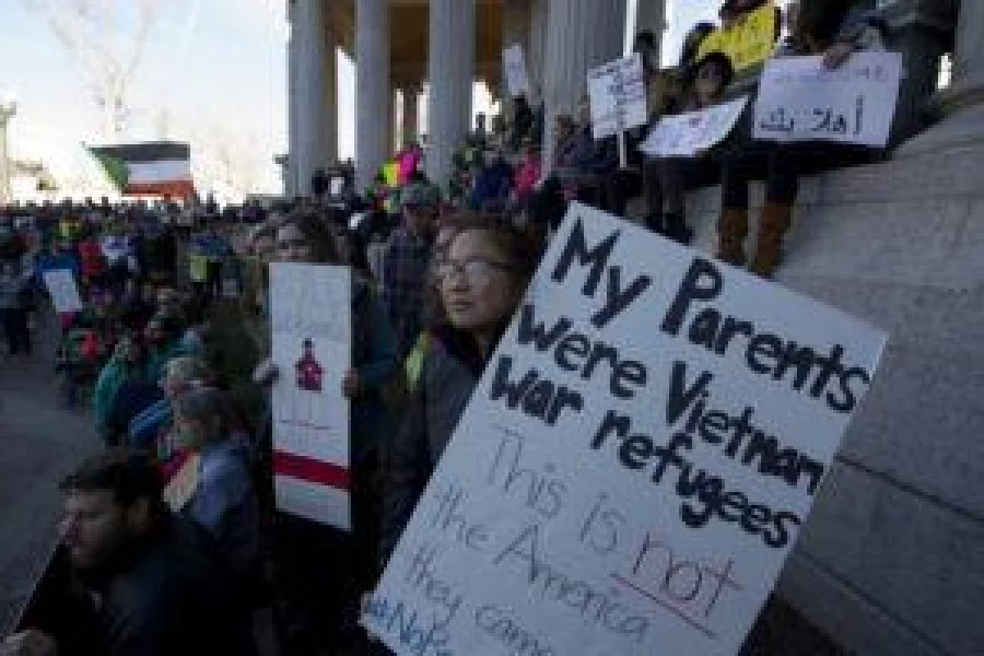 Diana Dang (C) gathers with thousands of people  at Civic Center Park in Denver, Colorado for the Protect Our Muslim Neighbors Rally on February 4, 2017.  The rally was held in response to the Executive Order issued one week ago banning nationals from seven predominately Muslim countries from entering the US. / AFP PHOTO / Jason Connolly