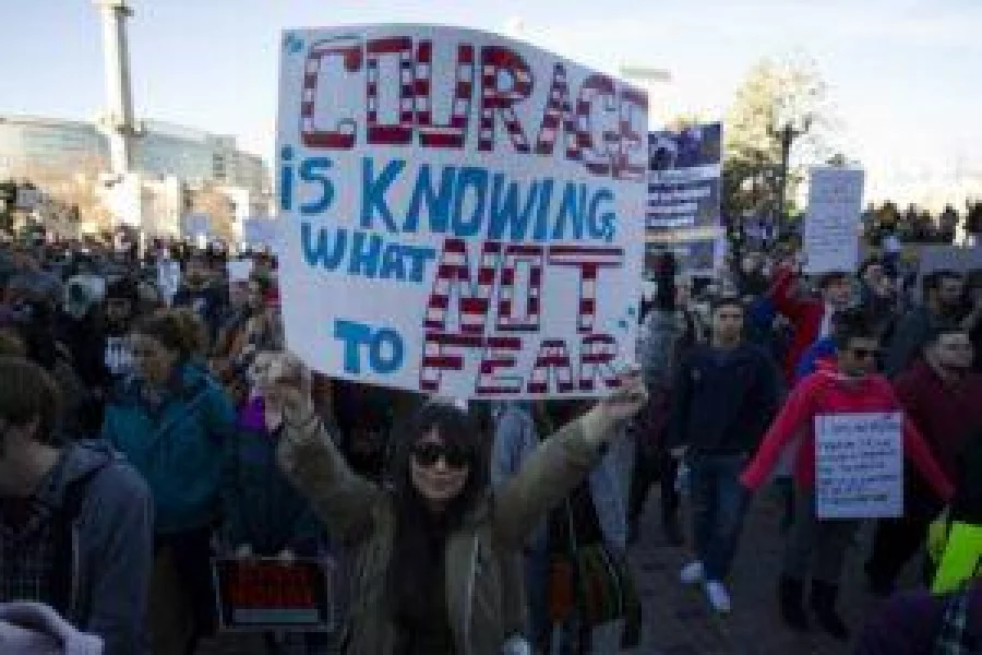 Jacquelyne Glover (C) joins thousands of supporters gathered at Civic Center Park in Denver, Colorado for the Protect Our Muslim Neighbors Rally on February 4, 2017.  The rally was held in response to the Executive Order issued one week ago banning nationals from seven predominately Muslim countries from entering the US. / AFP PHOTO / Jason Connolly