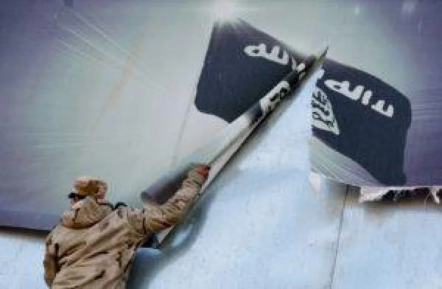 A member of the Iraqi security forces removes a banner bearing the logo of Isis in eastern Mosul last month AFP 