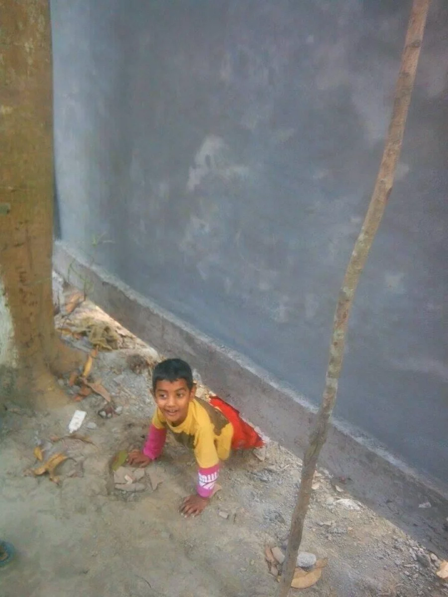 Some of the younger members crawl underneath the wall Dhaka Tribune
