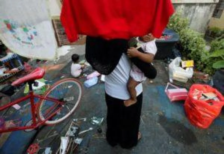 A Rohingya child bride who ran away from her husband carries her sister outside a shack she shares with her mother and siblings, on the outskirts of Kuala Lumpur, Malaysia, February 9, 2017. REUTERS/Lai Seng Sin