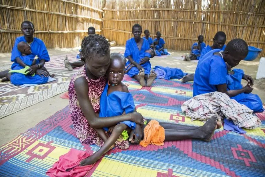 Two women hold their acute malnourished children on March 4, 2017, in a stabilisation centre in Ganyiel, Panyijiar county, in South Sudan. South Sudan was declared the site of the world's first famine in six years, affecting about 100,000 people. More than three years of conflict have disrupted farming, destroyed food stores and forced people to flee recurring attacks. Food shipments have been deliberately blocked and aid workers have been targeted. / AFP PHOTO / Albert Gonzalez Farran - AFP / Albert Gonzalez Farran