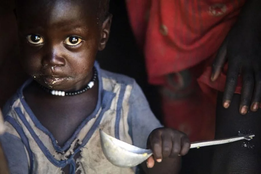 A boy eats out of a ladle at his home in Ngop in South Sudan's Unity State on March 10, 2017. The Norwegian Refugee Council (NRC) distributed food (maize, lentils, oil and corn soya blend) for more than 7,100 people in Ngop. South Sudan, the world's youngest nation formed after splitting from the north in 2011, has declared famine in parts of Unity State, saying 100,000 people face starvation and another million are on the brink of famine. Aid groups have slammed a "man-made" famine caused by ongoing fighting in the country where civil war has forced people to flee, disrupted agriculture, sent prices soaring, and seen aid agencies blocked from accessing some of the worst-hit areas. / AFP PHOTO / ALBERT GONZALEZ FARRAN