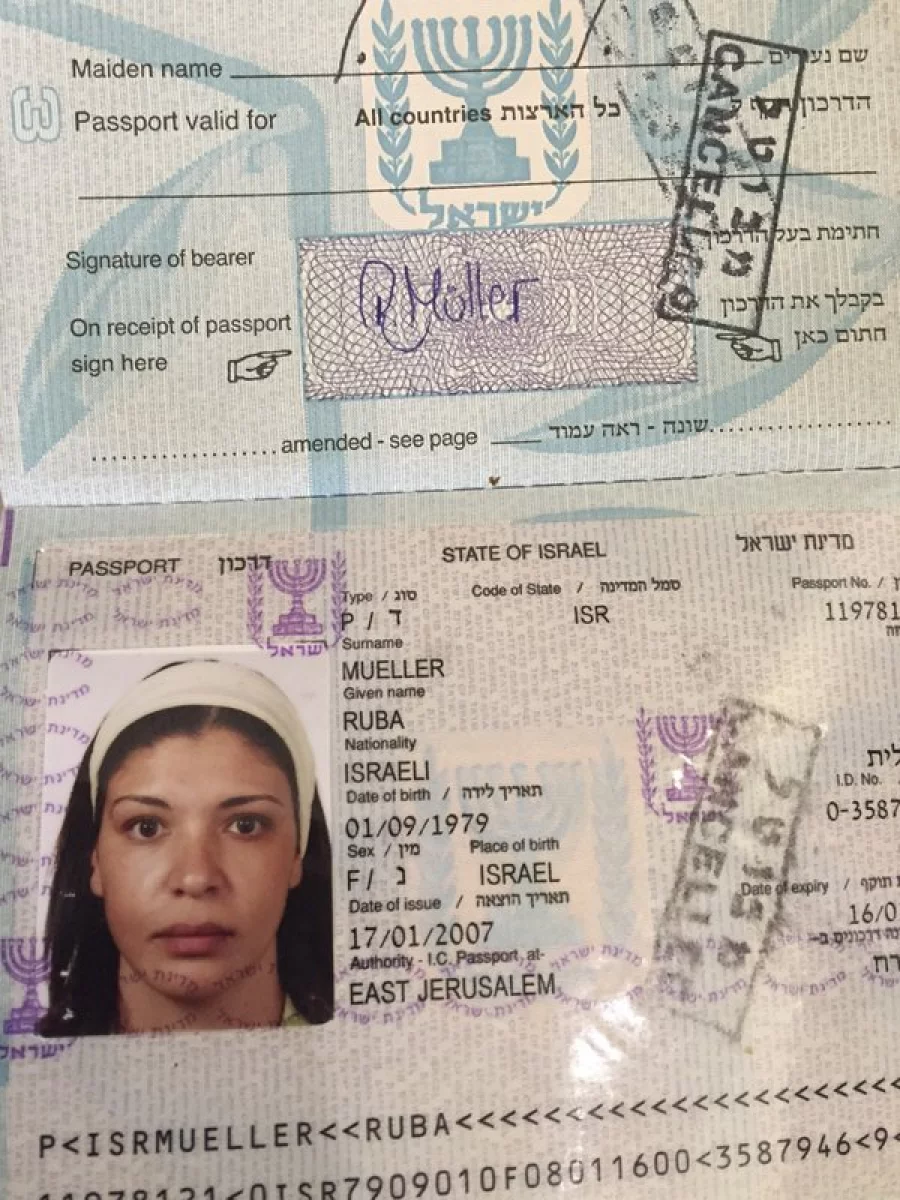 In this Tuesday, March 14, 2017 photo, a cancelled Israeli passport of a Jerusalem born Palestinian Israeli Ruba Mueller, is seen. Ruba was granted a German citizenship based on her marriage. Mueller learned recently that her passport wouldn't be renewed because she had left Israel immediately after obtaining it 10 years ago. She won't lose her citizenship, but has to go back to using a travel document that has to be renewed every two years. (AP Photo/Karin Laub)