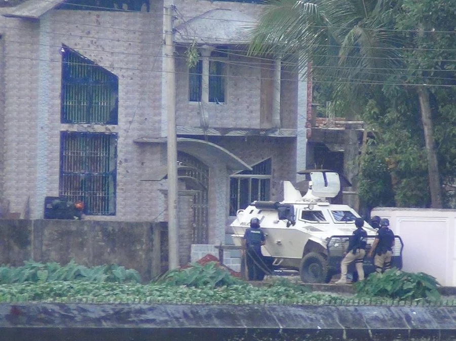 Law enforcement agency members attempt entry into the Borohat hideout using an APC Saiful Islam/Dhaka Tribune