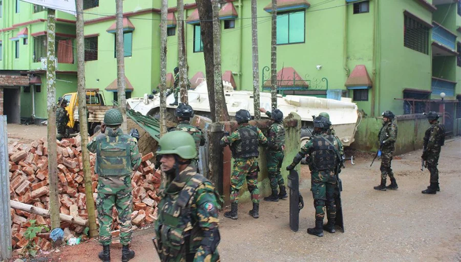 Army commandos are seen standing beside a armoured personnel carrier which rammed through the boundary walls of Atia Mahal, where a number of militants were holed in on Sunday; March 26, 2017 ISPR 
