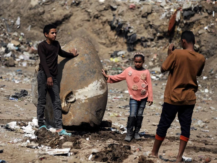 Matariya residents pose for pictures with what appears to be the head of an unearthed statue of Pharaoh Ramses II Mohamed Abd El Ghany/Reuters 
