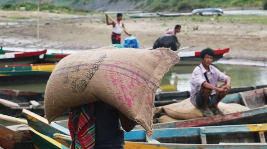 Instead of distributing relief among the starving people of Bandarban, many unscrupulous traders are selling the government-allotted sacks of rice to those desperate for food. In this photo from May 2016, a labourer is seen carrying a rice sack with a government seal to a boat in Thanchi Bazar, eventually to be sold elsewhere DHAKA TRIBUNE
