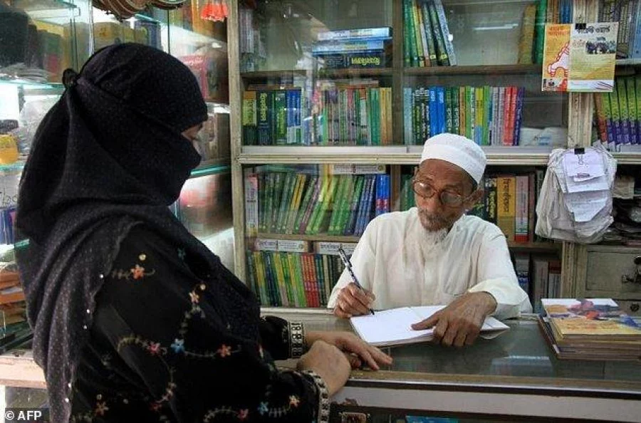 A devoted fan waits patiently as Abubakar signs one of his Islamic romance novels for her AFP