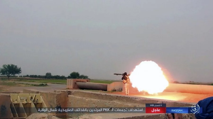 This undated image posted online Monday, May. 1, 2017, by supporters of the Islamic State militant group on an anonymous photo sharing website, purports to show an Islamic State fighter firing his weapon during clashes with U.S.-backed Kurdish-led Syrian Democratic Forces, in the northern Syrian province of Raqqa. The Britain-based Syrian Observatory for Human Rights and Kurdish activists said Tuesday, May 2, 2017, that a surprise attack in northeastern Syria carried out by IS has killed over 20 people, including displaced civilians. Arabic banner reads, "Targeting gatherings of the infidel PKK with rockets north of the province." (Militant Photo via AP)
