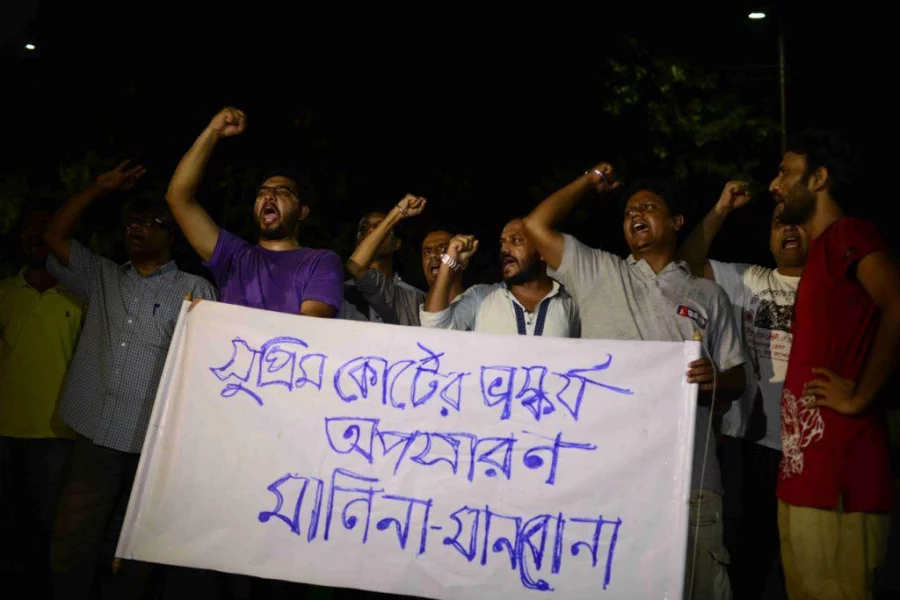 Protesters hold up a banner denouncing the removal of the Lady Justice statue Mahmud Hossain Opu