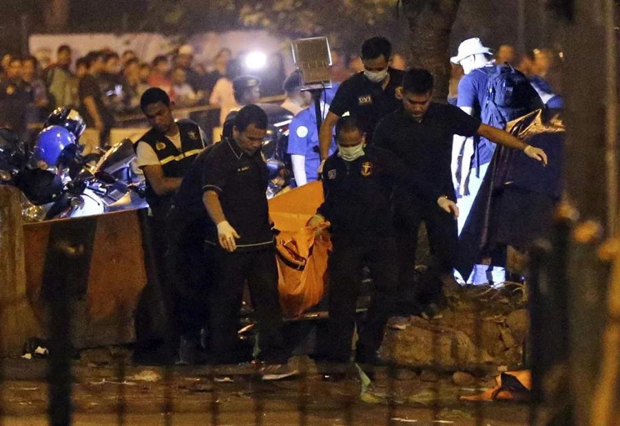 Police officers carry a body bag containing body parts from the site where a suspected suicide bombing occurred in Jakarta, Indonesia, Thursday, May 25, 2017 AP