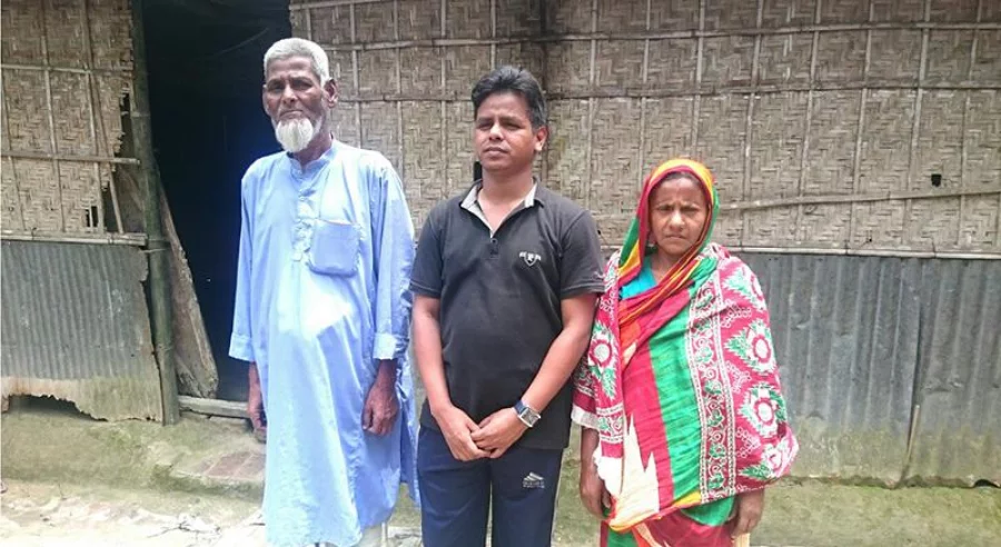 The BCS cadre stands in front of his home in Chawkidar Para with his parents Dhaka Tribune