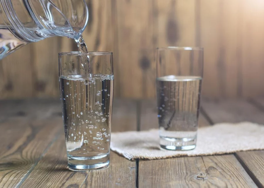 Glasses of water on a wooden table. Water was poured into the beaker. Selective focus. Shallow DOF. With lighting effects.