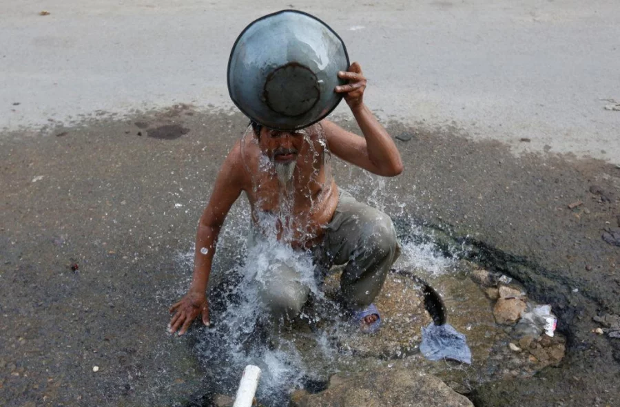 A man takes a bath, with water from a street tap, to cool off during a hot and humid day in Karachi, Pakistan on June 8, 2017 Reuters