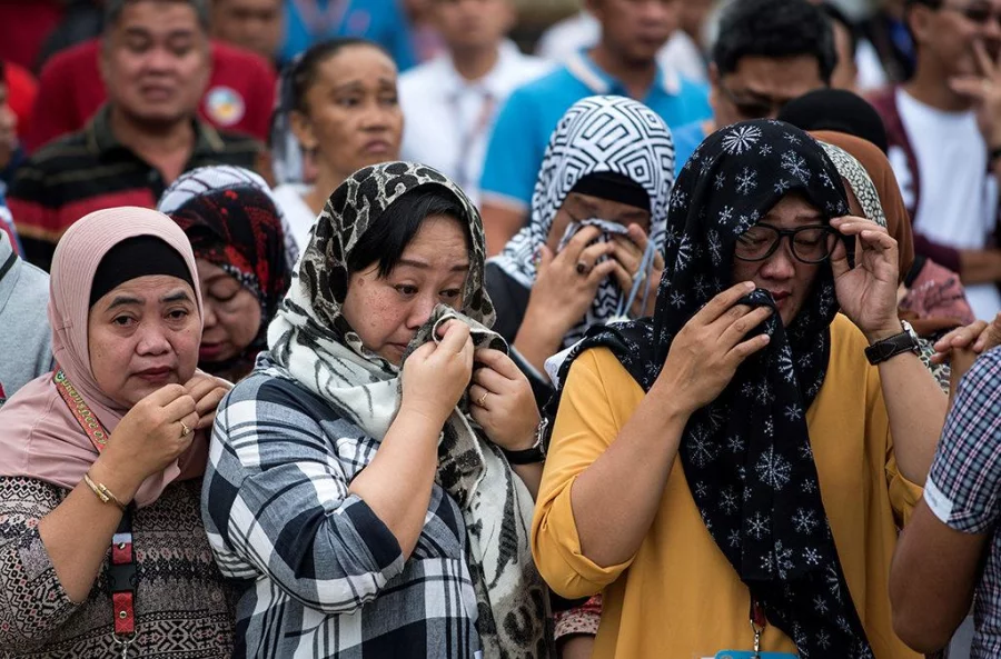 Local government employees cry as the Lano Del Sur Vice Governor Mamintal Adiong (not seen) gives a speech at the Lanao Del Sur provincial capital of Marawi on the southern island of Mindanao on June 12, 2017. Embattled Philippine troops struggling to force out Islamist militants from a southern city raised the national flag for Independence Day on June 12, in a tearful ceremony dedicated to the scores killed during the conflict AFP 