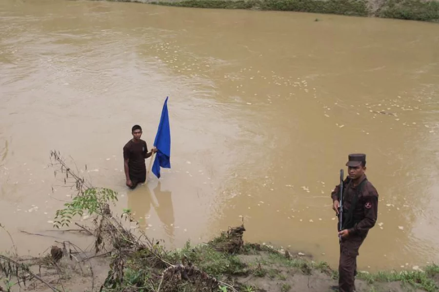 BGB jawans are marking the area with a flag where the boundary marker has submerged in Feni river due to land erosion